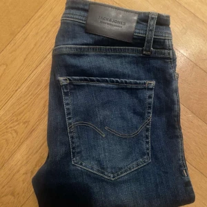 Marinblåa Jack & Jones Jeans - Säljer nu dessa fräscha Jack & Jones jeans utan defekter| de är köpta denna sommaren för 949 kr| säljs pga de inte kommer till användning något mer| priset är diskuterbart!| vid några frågor eller funderingar är det bara att höra av sig!