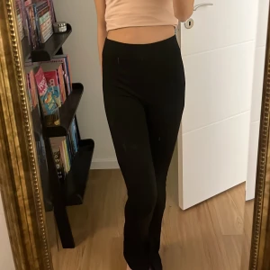 Svarta utsvängda  leggings - Snygga svarta leggings med hög midja. Med en slit ner vid anklarna som gör att det blir mer utsvängd och flare stil! Perfekta för en bekväm och stilren look. Passar bra till både avslappnade och mer uppklädda tillfällen.