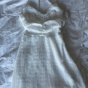 Studentklänning - Supergullig vit klänning med korsrygg, perfekt till studenten!! Endast använd en gång så den är i superfint skick, skriv om ni vill ha fler bilder 🩷