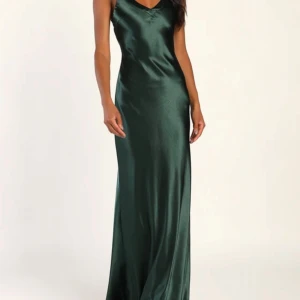 Grön långklänning i satin - En superfin grön balklänning från lulus med öppen rygg som går hela vägen till marken på mig som är 173 cm. Aldrig använd och lapparna är kvar då jag valde en annan.