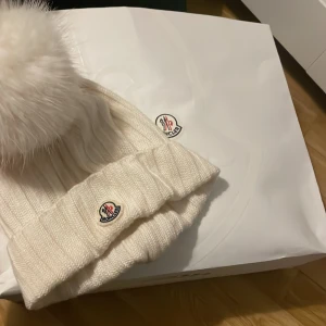 En vit moncler mössa, perfekt för vinter!  - En vit moncler mössa, ÄKTA det går att skanna och kommer i påsen som man fick vid köpet.  Ordinarie pris 3600  Pris går att diskutera 