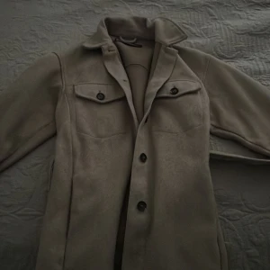 Beige jacka från Zara, köpt för 600kr - Säljer en snygg beige jacka från Zara i storlek XS. Jackan har en klassisk design med knappar framtill och två bröstfickor med knappar. Perfekt för höst och vår!
