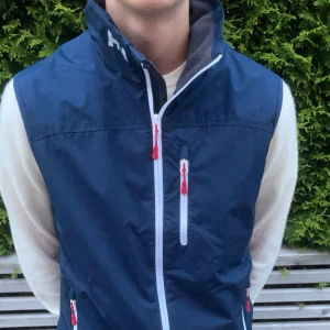 Helly Hansen Väst - Stört snygg Marinblå Helly Hansen väst i storlek M. Skick 9,5/10 finns inga defekter. Nypris 1600kr mitt pris 500🔥 