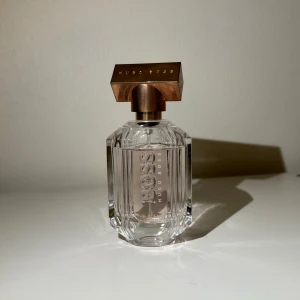 Hugo Boss The Scent Eau de Toilette - Säljer en elegant och lyxig parfym från Hugo Boss, The Scent. Flaskan är gjord av genomskinligt glas med en stilren design och har en snygg bronsfärgad kork. Perfekt för både vardag och speciella tillfällen. Flaskan innehåller 50 ml av denna fantastiska doft.