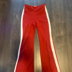 Röda bootcut byxor  - Röda bootcut byxor från hm. Tighta vid låren och utsvängda där nere. Skriv om fler bilder önskas. Mycket bra skick.