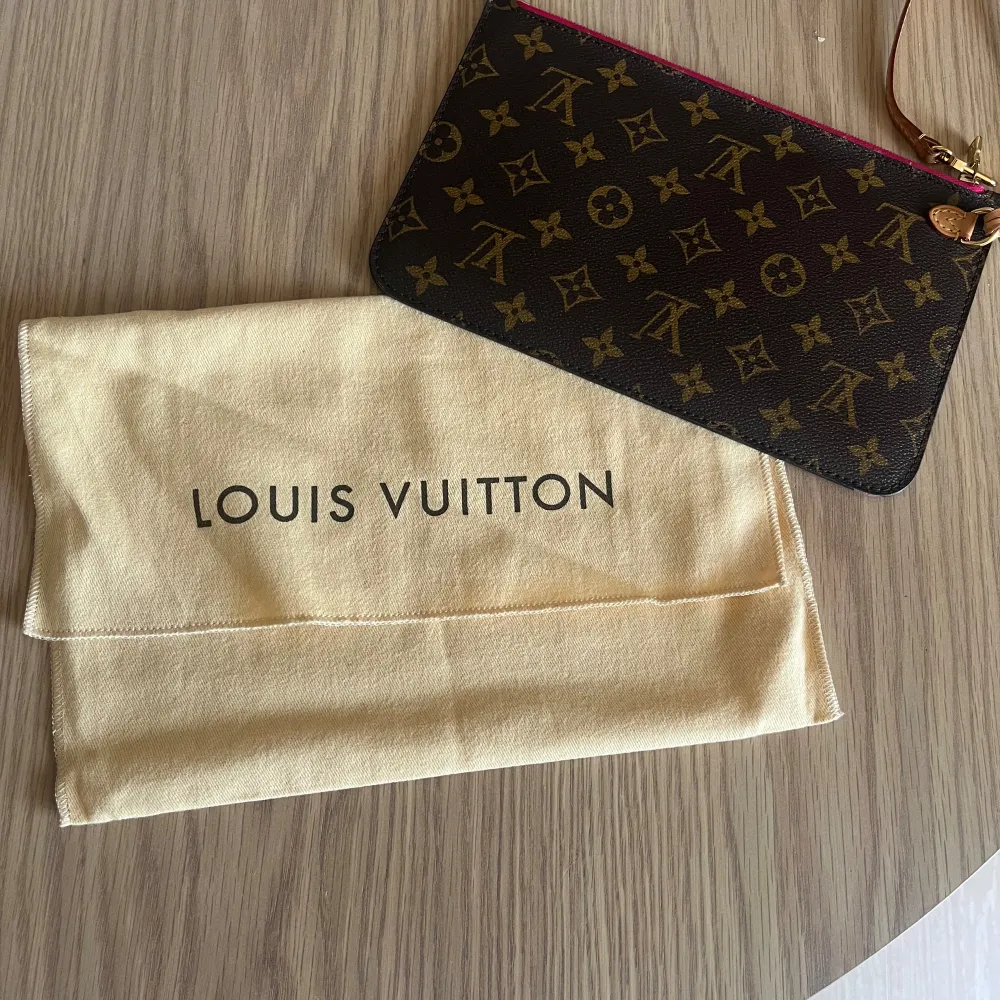 Pochette från Louis Vuitton. Neverfull. Inköpt från A retro tale. Superfint skick, endast använd ett fåtal gånger.. Väskor.