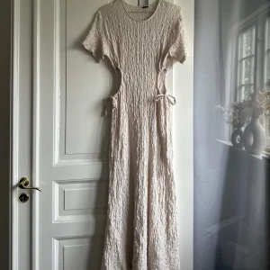 Klänning - Klänning från Gina Tricot i storlek M, använd en gång som strandklänning då den är något genomskinlig. Går att justera i midjan. 