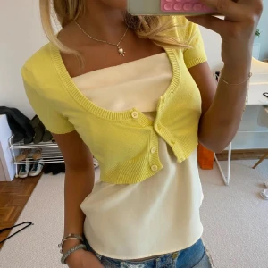 Gul kortärmad bolerotopp - Säljer en söt gul bolerotopp med korta ärmar och knappar framtill!