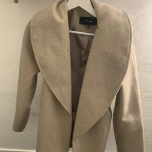 Beige kappa från Vero Moda - Säljer en elegant beige kappa från Vero Moda i mycket bra skick. Den har en stilren design med långa ärmar och en öppen framsida. Perfekt för höst och vår, och ger en chic touch till vilken outfit som helst. Storlek M men är mer som en blandning mellan S/M. Pris kan diskuteras 💕