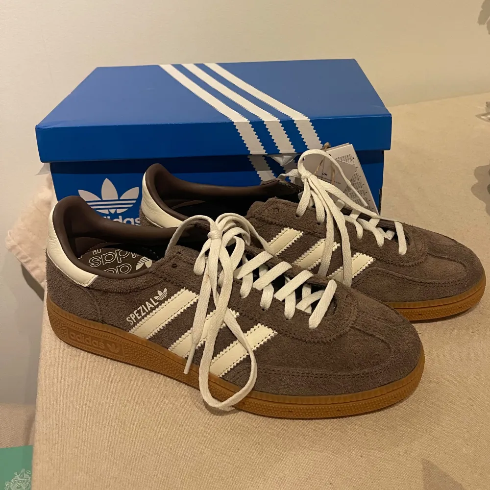 Säljer dessa populära bruna Adidas Handball Spezial. Perfekta för både vardag och träning. De är i nytt skick och kommer med originalkartong. Strl 39 1/3. Skor.