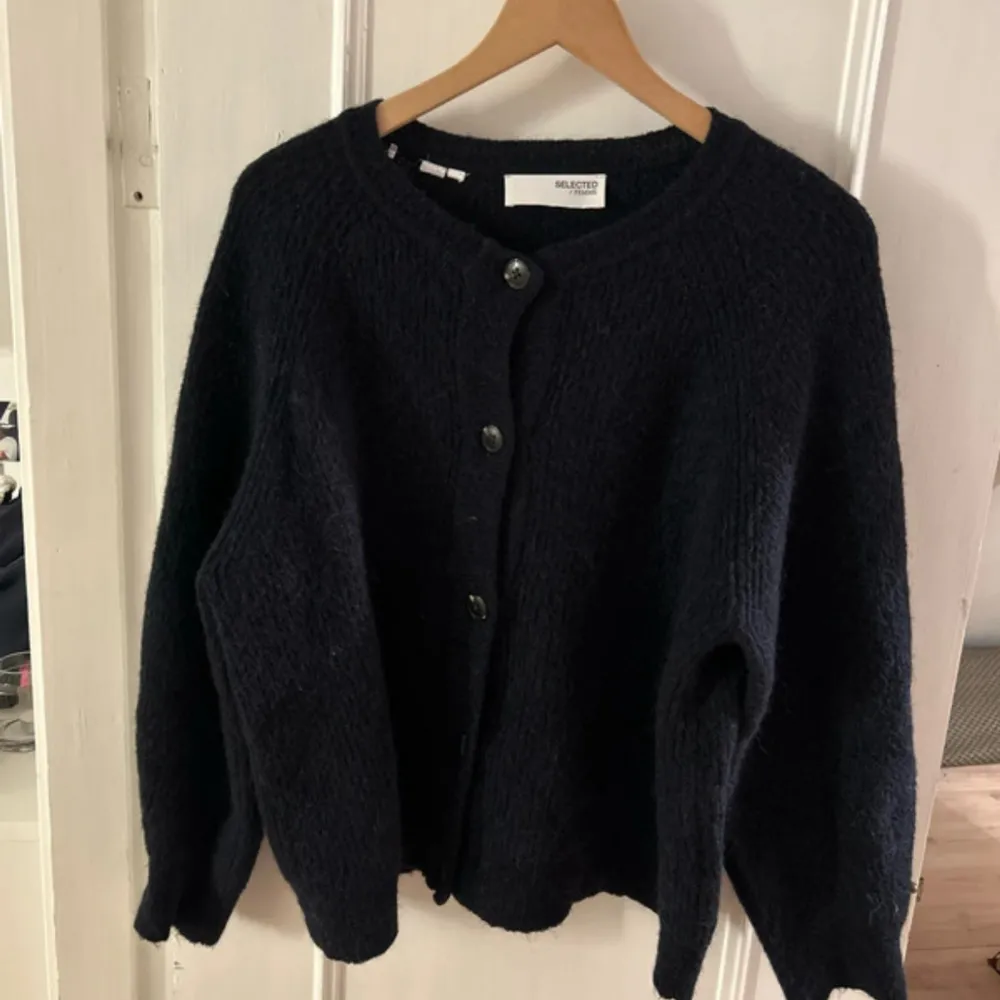 Säljer en snygg svart kofta från Selected Femme. Perfekt för höst och vinter, och den är i mycket bra skick. Koftan har långa ärmar och är supermysig att ha på sig när det är kallt ute. Skriv för frågor och fler bilder, pris kan diskuteras vid snabb affär! 💗💗. Neuletakit & Villapaidat.