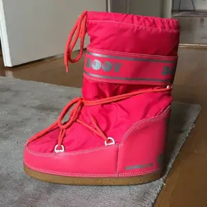 Säljer ett par coola rosa vinter boots som är i samma design som moon boots,  i bra skick. De har en snygg snörning och är perfekta för vintern. Skorna har en robust sula och är supervarma, idealiska för kalla dagar. Storlek 38-40. Snörerna är lite slitna, annars inga defekter 