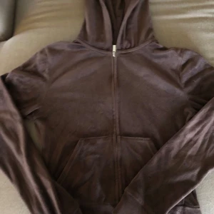 Brun hoodie med dragkedja - Mysig brun hoodie i mjukt material med dragkedja framtill. Perfekt för en avslappnad stil och passar bra till jeans. Den har långa ärmar och en praktisk huva för extra komfort.