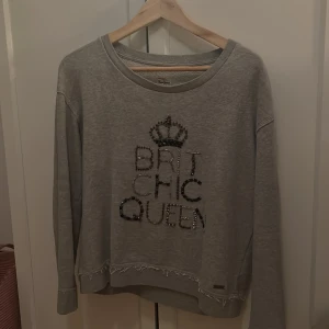 Grå sweatshirt från Pepe Jeans - Säljer en snygg grå sweatshirt från Pepe Jeans med text i glittriga stenar på framsidan. 