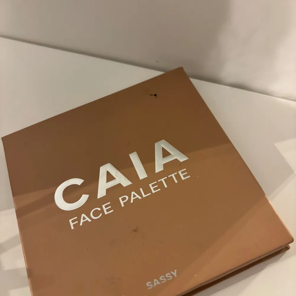 Snygg face palette från CAIA i nyansen Sassy. Innehåller bronzer, rouge och highlighter i en praktisk förpackning med spegel. Perfekt för att skapa en fräsch look med naturlig glöd. Paletten har en stilren design i brunt.. Skönhet.