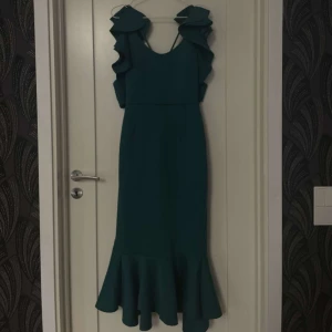 Mörkgrön Klänning med Detaljer - Säljer denna mörkgröna klänning med fina detaljer. Detta är en väldigt stilren och unik klänning som definitivt behöver mer kärlek. Säljer för 499:-