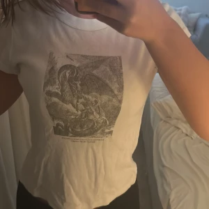 Vit t-shirt med tryck från John Galt - Den är köpt för några år sedan men inte använt mycket alls 