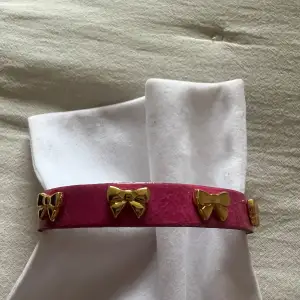 Säljer ett snyggt rosa armband med guldfärgade rosetter. Perfekt för att piffa upp en outfit till fest!💖 Hekt nytt! Nypris 399kr