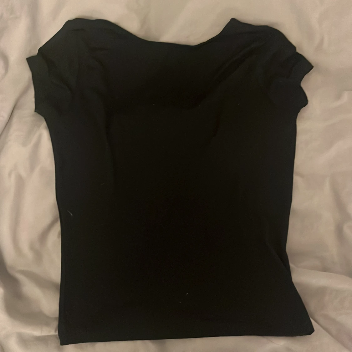 Svart t-shirt med urringad rygg och rosett i siden - 90