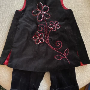 Klänning - byxset  - Fint det med klänning och tillhörande byxor. I klänningen står storlek 12 månader och i byxorna 3-6 månader men de är köpta tillsammans och användes av min dotter när hon var 6-12 månader 