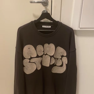 Acne Studios Sweatshirt Bubble - Säljer en snygg svart tröja från Acne Studios med ett coolt, stort tryck på framsidan. Perfekt för en avslappnad stil. Tröjan är knappt använd.          acne studios fn-mn-swea000311
