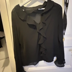 Svart blus med volang  - Superfin blus från anna field, lite genomskinlig men blir superfint med ett svart linne under