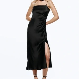 Svart satinklänning - Snygg svart klänning från Zara i satin med smala axelband och slits i storlek XS. Endast använd en gång ❤️