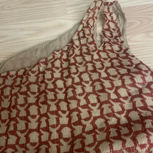 Linne  - Cool topp med en ärm! Roströd i färgen med små glittertrådar i. 