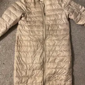 Säljer en snygg beige dunjacka från Zara Basic i storlek XS. Jackan har en dragkedja framtill och är quiltad för extra värme. Perfekt för kyliga höst- och vinterdagar. Den är i  bra skick och redo för nya äventyr!