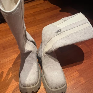 Beige boots med dragkedja - Säljer ett par snygga beige boots från Eytys i mycket bra skick. De har en praktisk dragkedja på sidan och är gjorda i ett robust material som ser ut som mocka. Perfekta för höst och vinter med sin rejäla sula. Passar både till vardags och lite mer uppklädda tillfällen.