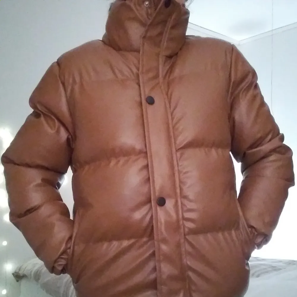 HELT NY OCH OANVÄND snygg brun höst/vinterjacka i läderimmitation. Strlk: Small, 36. Polyuretan, polyester/vadderad. Har dragkedja, knappar, fickor. Liten defekt: hållaren på dragkedjan saknas men kan lätt lagas själv el hos skräddare. Fungerar dock!. Takit.