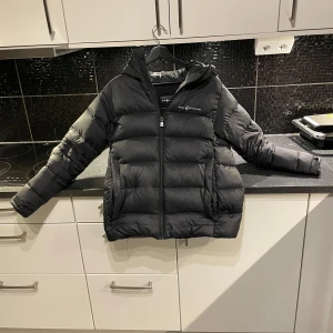 Sail Racing jacka strl xs/170 - Säljer en svart pufferjacka från Sail Racing i hyfsat bra skick. Perfekt för både höst och vinter! De är en en liten lagning på höger arm men inget som syntes på nära håll! Passar dig som är ca 165-175🙃