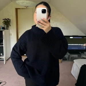 Stickad glittrig ulltröja med polokrage - Grovt stickad mysig ulltröja, lite längre i modellen med slits och polokrage! Aldrig använd, lappar finns kvar 🥰 Den är svart med lila insytt glitter 💓 Nypris: 990 kr