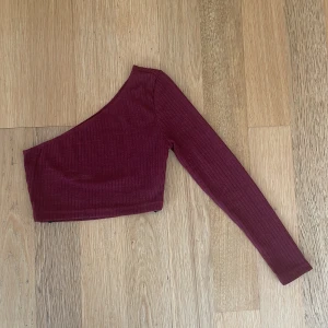 Off-shoulder topp - Cool off-shoulder tröja med en ärm. Säljer för att den inte passar och den är därför aldrig använd. (Står att den är storlek S, men passar mer som Xs). Är öppen för prutning🫶🏼