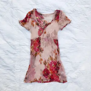 Söt, skir topp med volangdetaljer. Rosa med romantiskt blommönster. Storlek uppskattad till M. Material krinklad viskos, så lite stretchig. Köpt second hand. I mycket fint begagnat skick, ingenting att anmärka på.