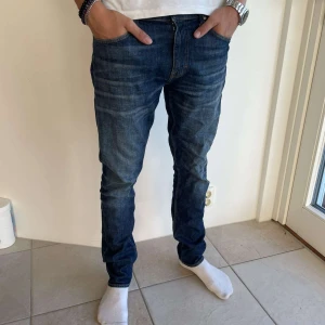 Mörkblå jeans från Tiger of Sweden - Säljer ett par snygga mörkblå jeans från Tiger of Sweden i modellen Pistolero. Storleken 31/34.De är i bra skick och har en klassisk femficksdesign. Perfekta för både vardag och fest!