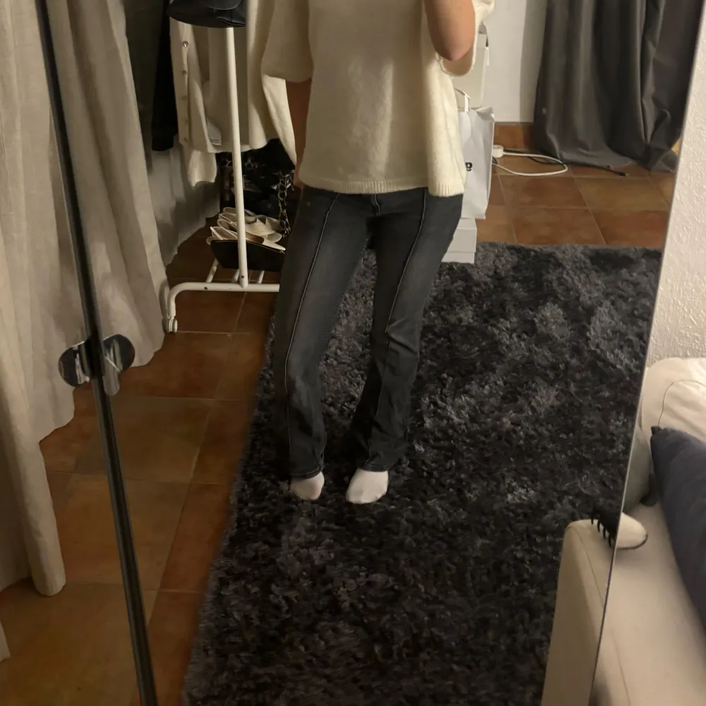 Grå/svarta lågmidjade bootcut jeans från bershka. Slitningar längst ner vid fötterna💗. Jeans & Byxor.