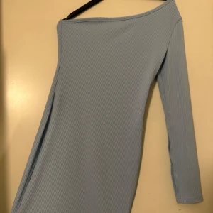 Blå klänning  - Fin ljusblå klänning med en ärm som bara är använd en gång.