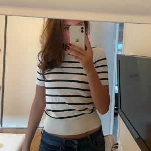 Randig kortärmad topp - Säljer en superfin vit och blå randig topp med korta ärmar från Zara. Toppen har en tight passform och går att ha lite croppad. Bra skick!