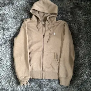 Säljer denna zip hoodie från Ralph Lauren i en najs beige färg 🙌 Tröjan är i storlek M och är i ny skick 🤩 Priset är ej hugget i sten, hör av er för fler bilder 👏