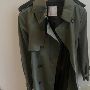 Trenchcoat Khaki/Grön Mango - Köpt från Mango i Köpenhamn i våras för 1499kr. Aldrig använd endast provad. I nyskick utan kvitto eller etikett.  Storlek: S