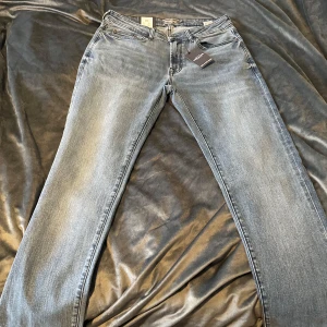 Jeans från Dressmann - Säljer ett par snygga jeans från Dressmann i storlek 31/34. De är i en klassisk blå färg med en lätt tvättad look. Perfekta för både vardag och fest! 🕺