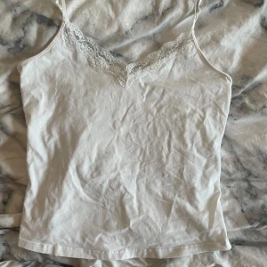 Vitt linne med spets - Är i storlek XL men passar som M. Den har justerbara axelband och är jättesnygg!!