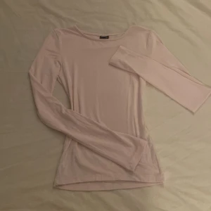 Ljusrosa långärmad topp - Säljer en stilren ljusrosa långärmad topp. Perfekt för en enkel och elegant look. Toppen har en rund halsringning och är gjord i ett mjukt material som känns skönt mot huden. Tröjan är lite skrynklig men kan bara tvättas eller strykas så försvinner det. Pris kan diskuteras!