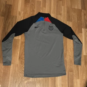 Grå barcelona träningströja - Säljer en grå långärmad barcelona träningströja från Nike. Perfekt för fotbollsträning eller annan sportaktivitet. Pris kan diskuteras!