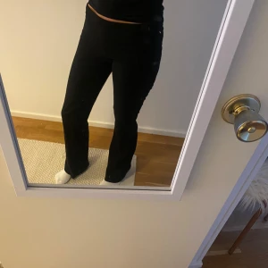 Svarta byxor - Snygga svarta byxor med en tight passform och bootcut-stil. Perfekta för en stilren look.