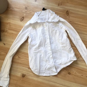 Vit skjorta från OVS Kids - Säljer en klassisk vit skjorta från OVS Kids. Skjortan har långa ärmar och knappar framtill. Perfekt för både vardag och speciella tillfällen. Passar ungdomar i åldern 13-14 år.