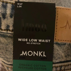 Wide Low Waist Jeans från Monki - Snygga wide low waist jeans från Monki i en ljusblå tvätt. Tillverkade av ekologisk och återvunnen bomull, dessa jeans har en avslappnad passform med raka ben och klassisk femficksdesign. Perfekta för en trendig och bekväm stil.
