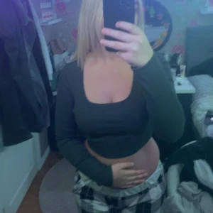 Mörkgrå croppad topp - Säljer en mörkgrön croppad topp med långa ärmar. Perfekt för en trendig och avslappnad stil. Toppen har en enkel design som gör den lätt att matcha med olika outfits.