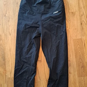 Stronger - Snygga svarta leggings från Stronger med diskret leopardmönster. Perfekta för träning eller en aktiv vardag. Tillverkade i ett stretchigt material för optimal komfort och passform.